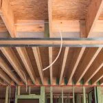 Platdak plafond waarbij de houten balken nog niet gevuld zijn met isolatie